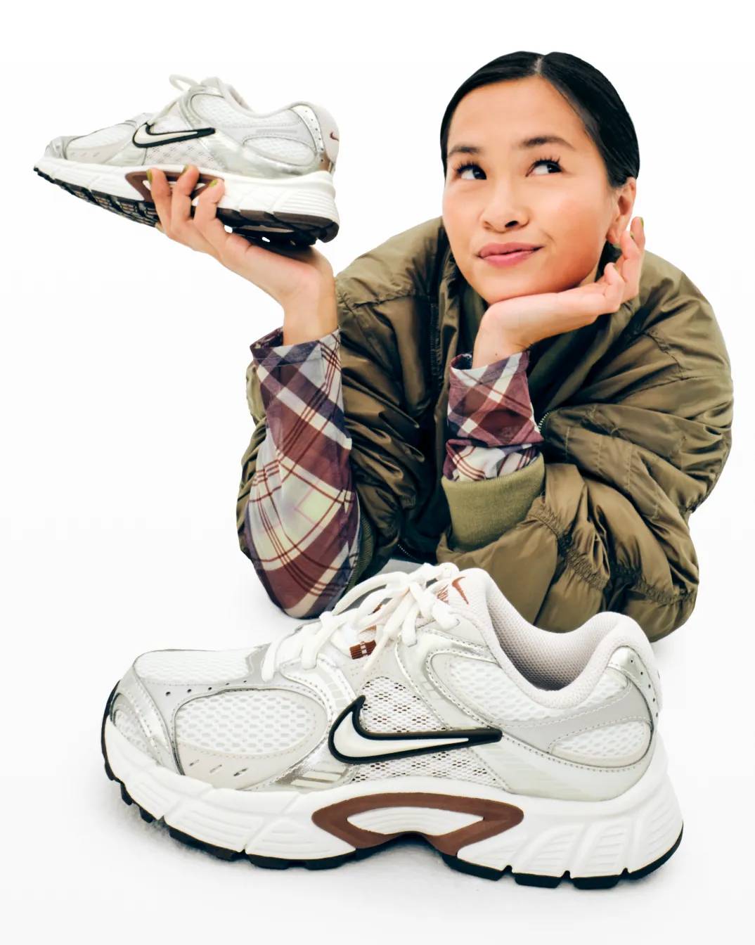 Featuring a model holding Nike sneakers