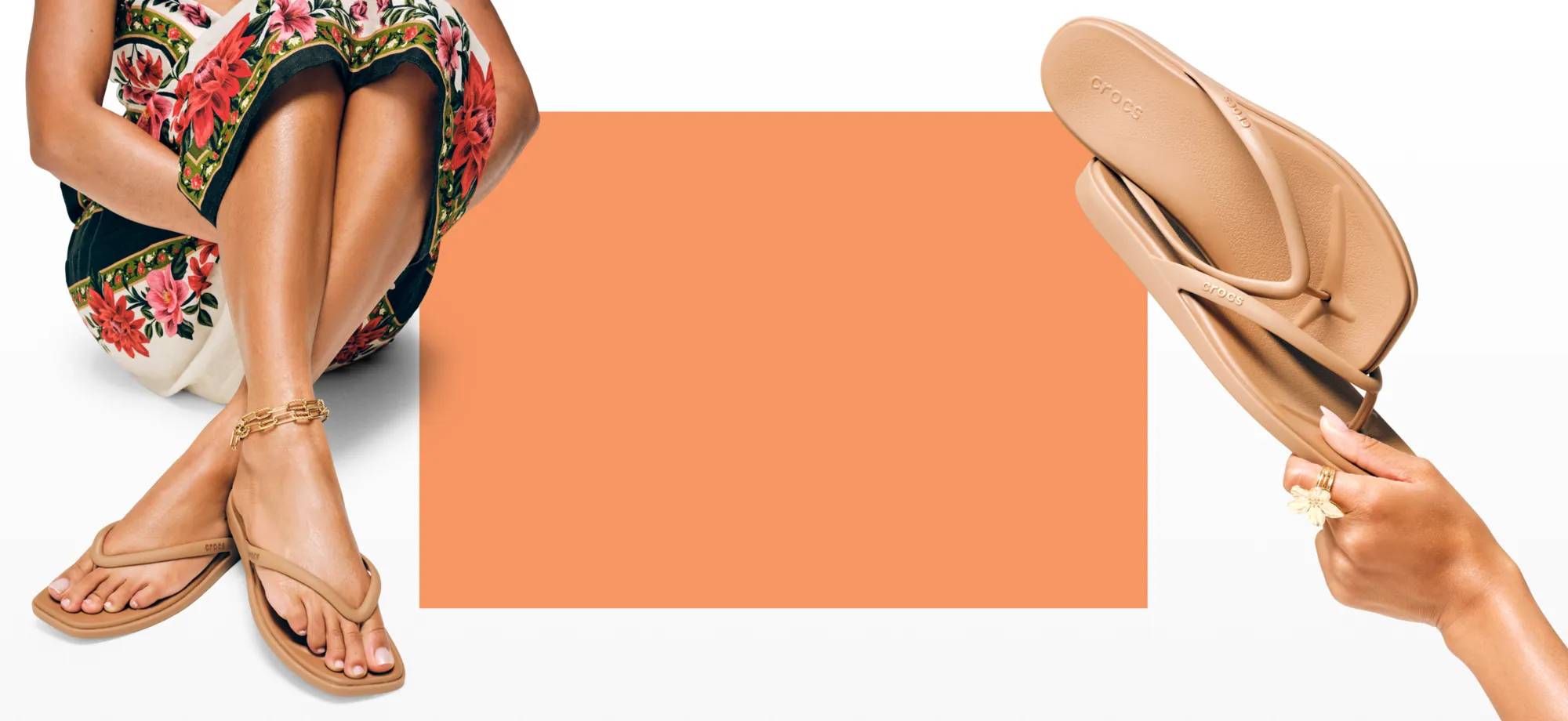Person in dress wearing nude flip flops, hand holding up a pair of flip flops