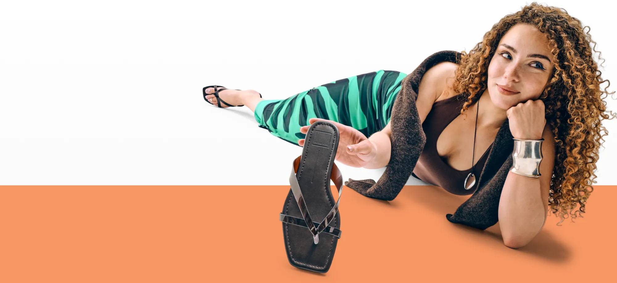 Featuring a woman holding a black dress sandal.