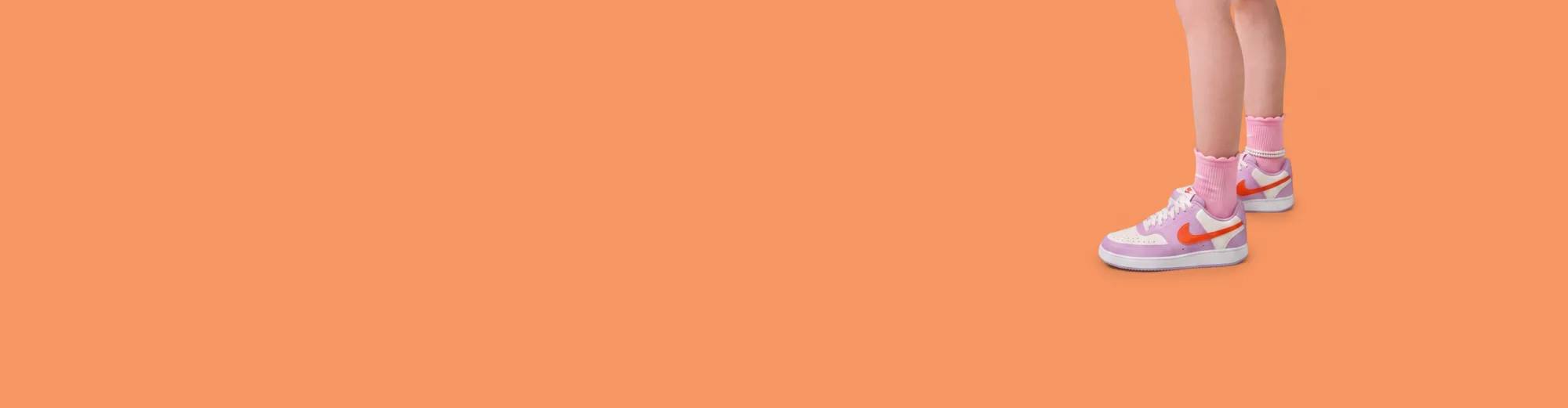 Featuring a pair of pink, white, and orange Nike sneakers.