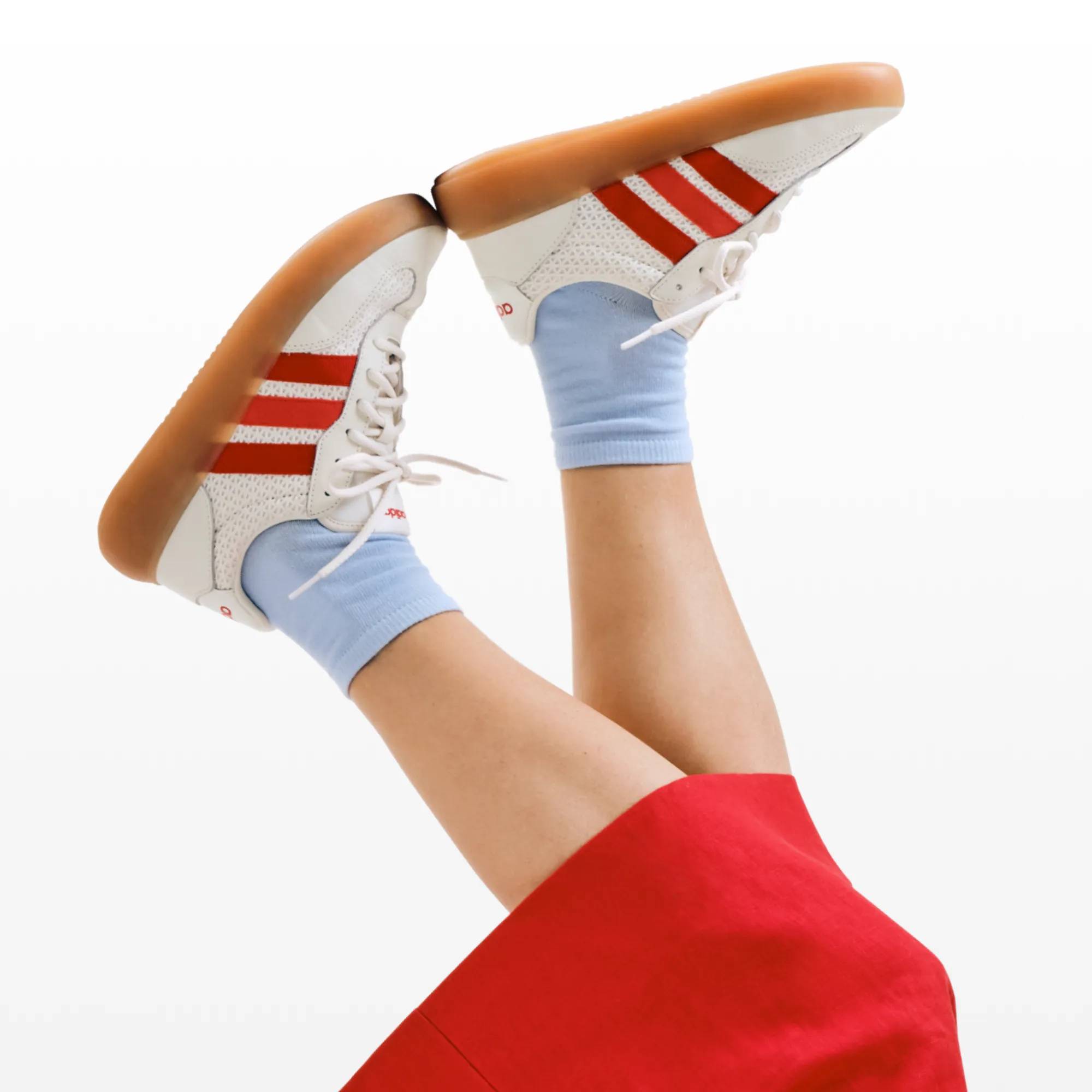 Featuring a pair of adidas court sneakers with red accents.