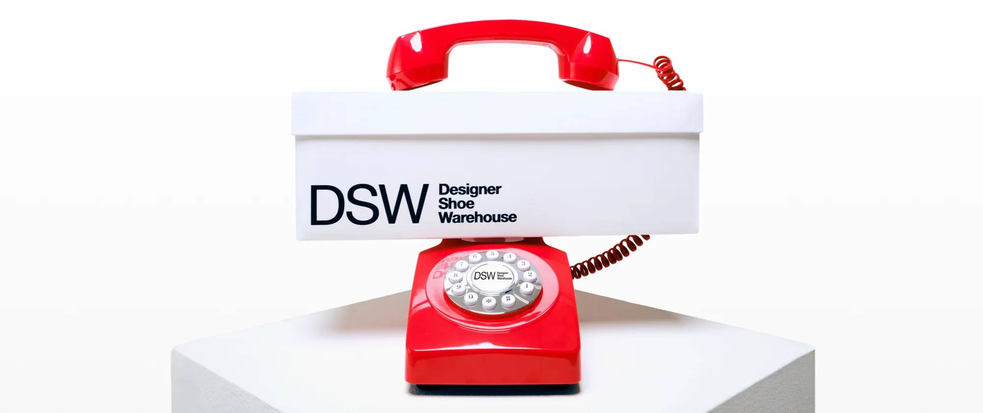 Featuring a red telephone with a shoe box from DSW Designer Shoe Warehouse.