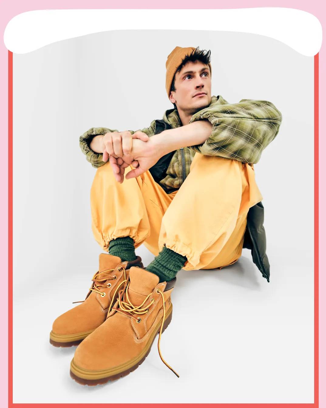 Featuring a model holding a pair of Timberland boots.
