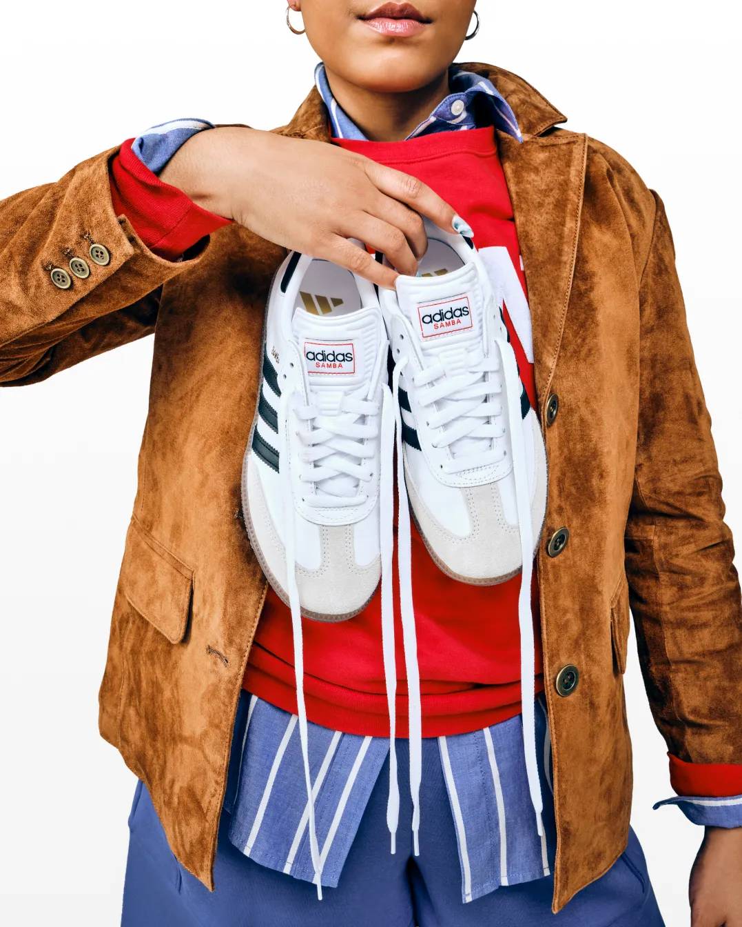 Featuring a woman holding a pair of adidas sneakers.