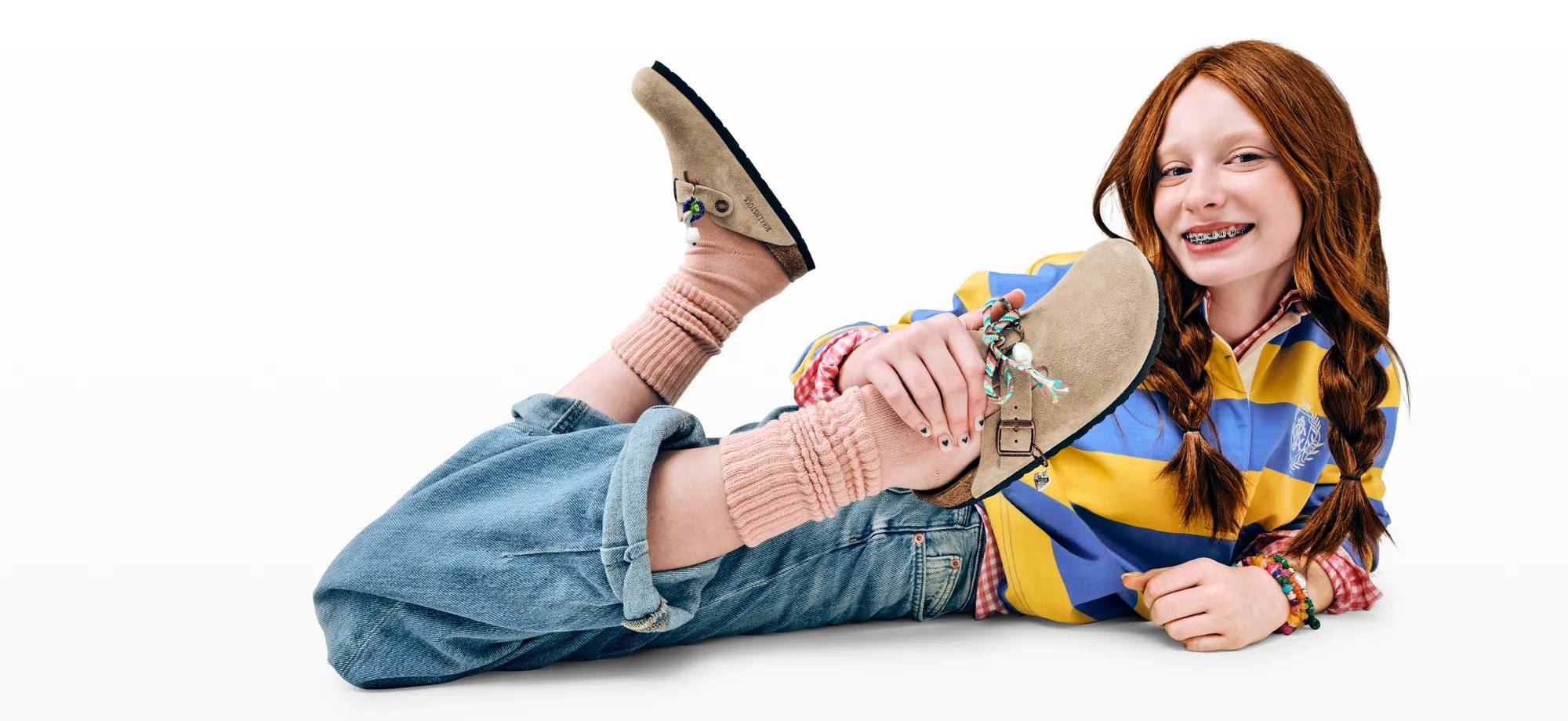 Featuring a young girl wearing Birkenstock clogs.