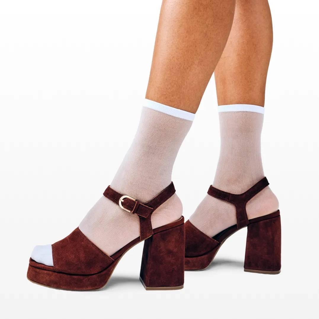 Featuring a model in suede boots with a suede purse.