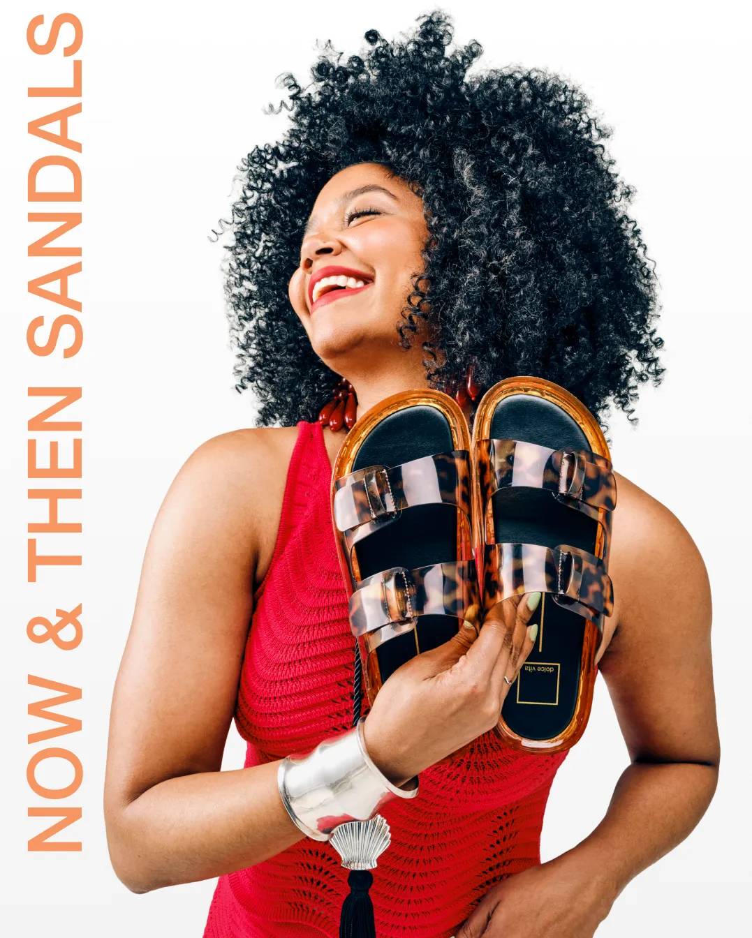 Featuring a model holding a pair of Tortoise shell sandals