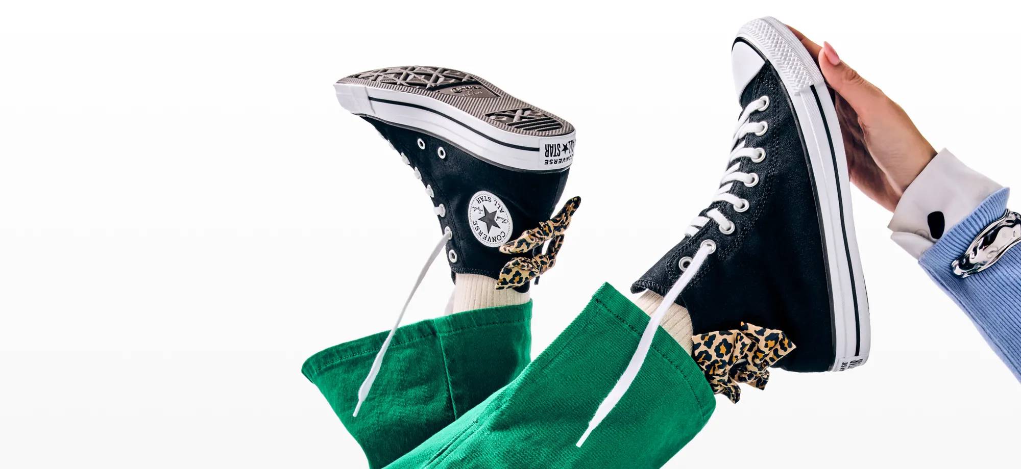 Featuring a pair of Converse sneakers with animal print bows on the backs of them.