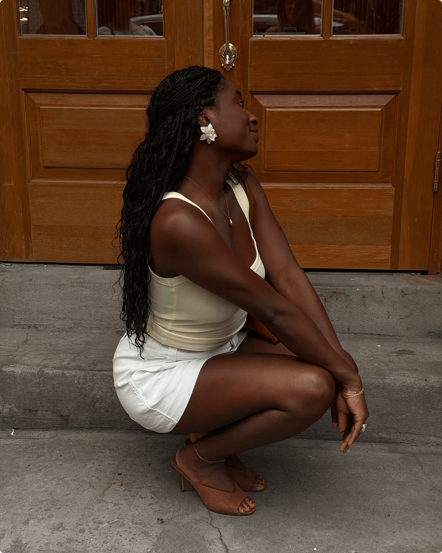 Featuring a model kneeling down wearing brown heels.