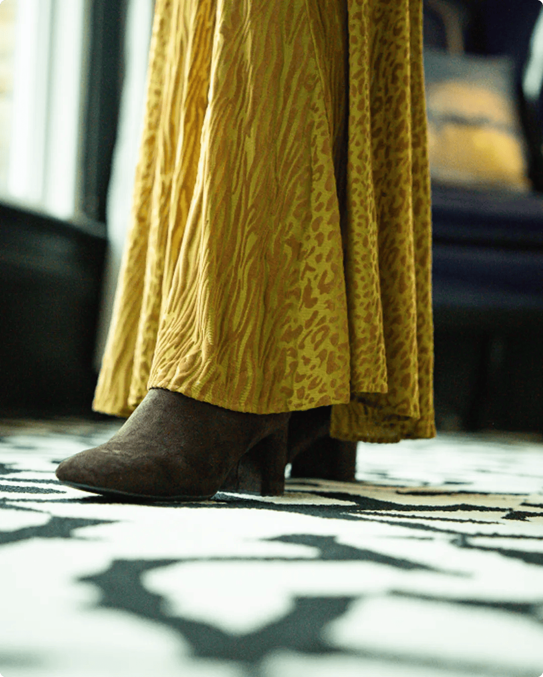 Featuring a bright green animal print skirt and brown boots.