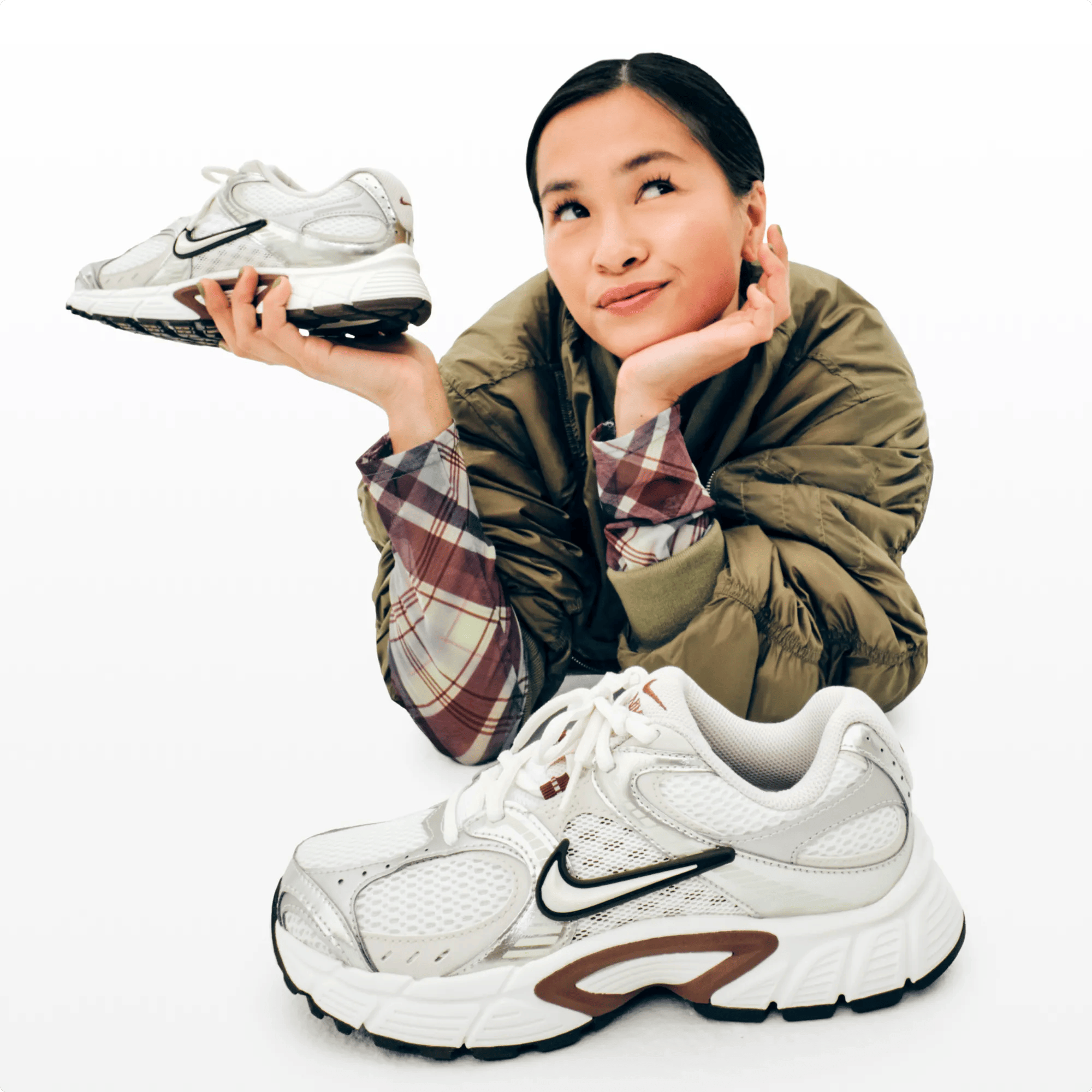 Featuring a woman holding a pair of sneakers.
