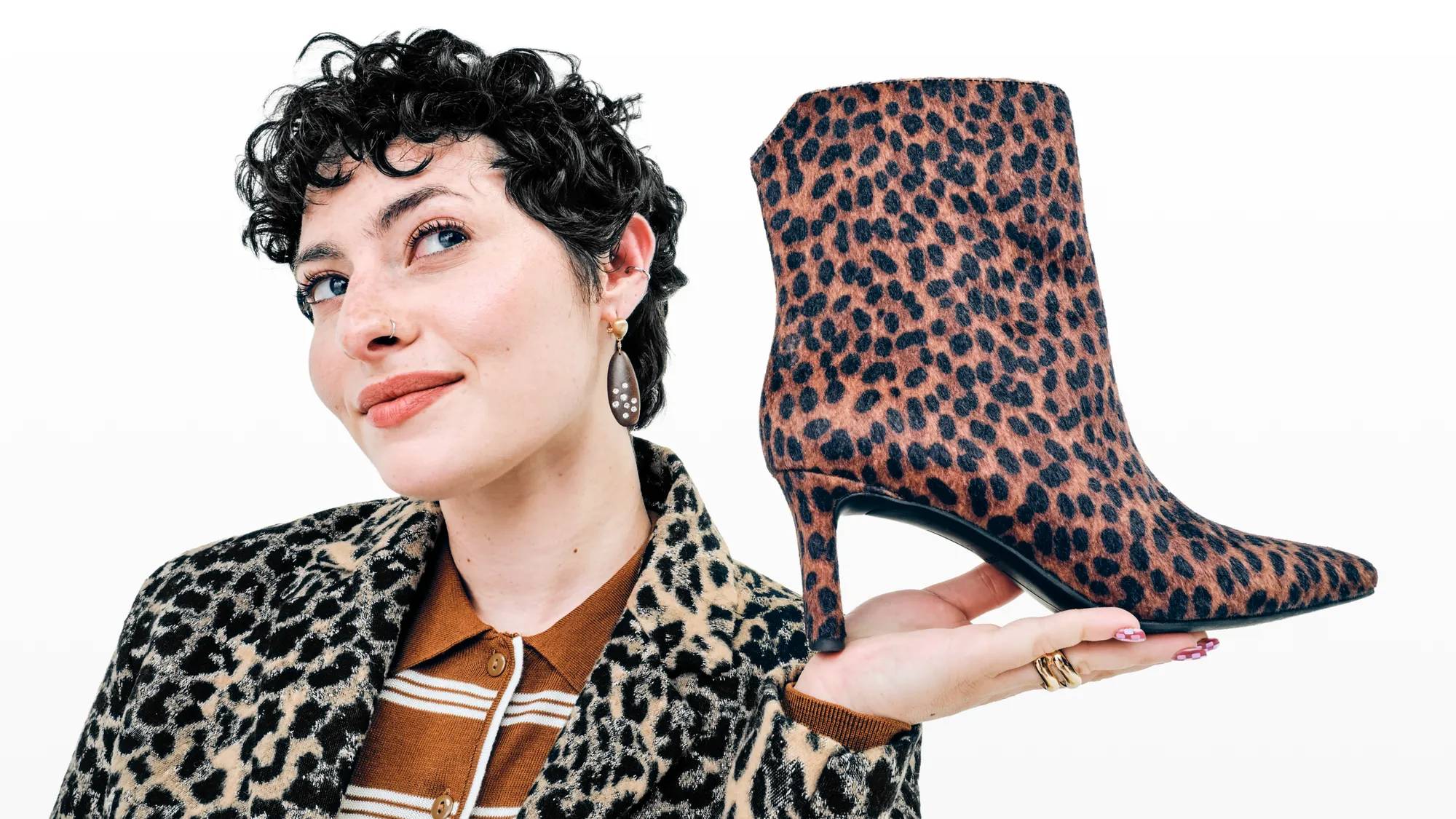 Women holding a pair of leopard print ankle boots.