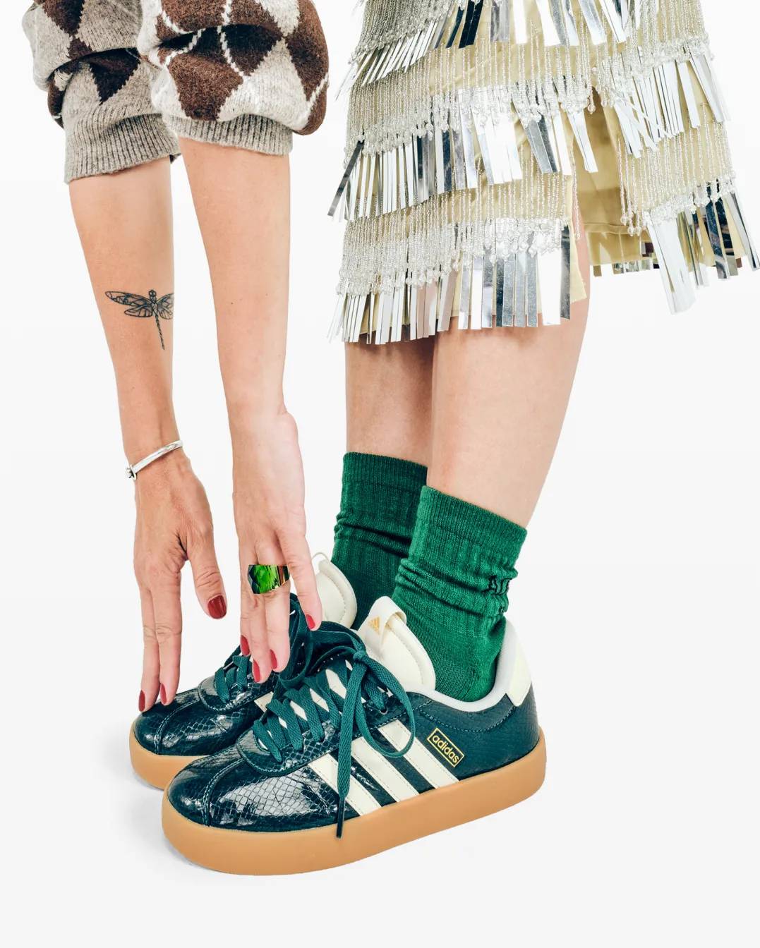 Featuring a woman stretching down to reach her toes, whilst in a green adidas sneaker.