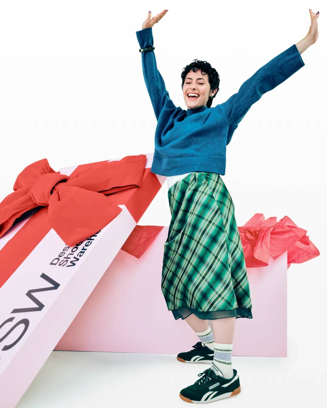 featuring a woman excited next to a huge holiday shoebox from DSW.