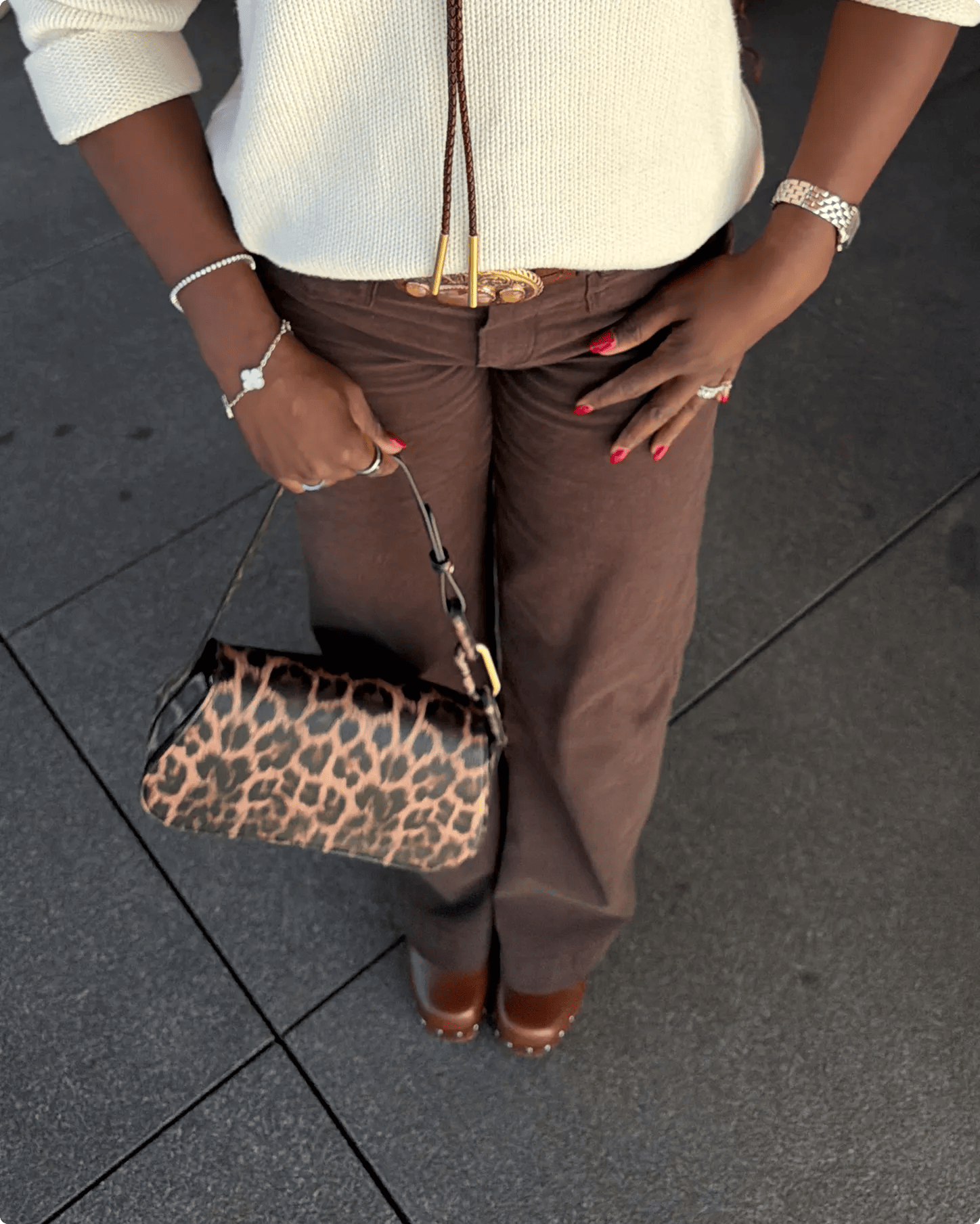 Featuring Barbarah William wearing brown studded clogs and holding an animal print shoulder bag.