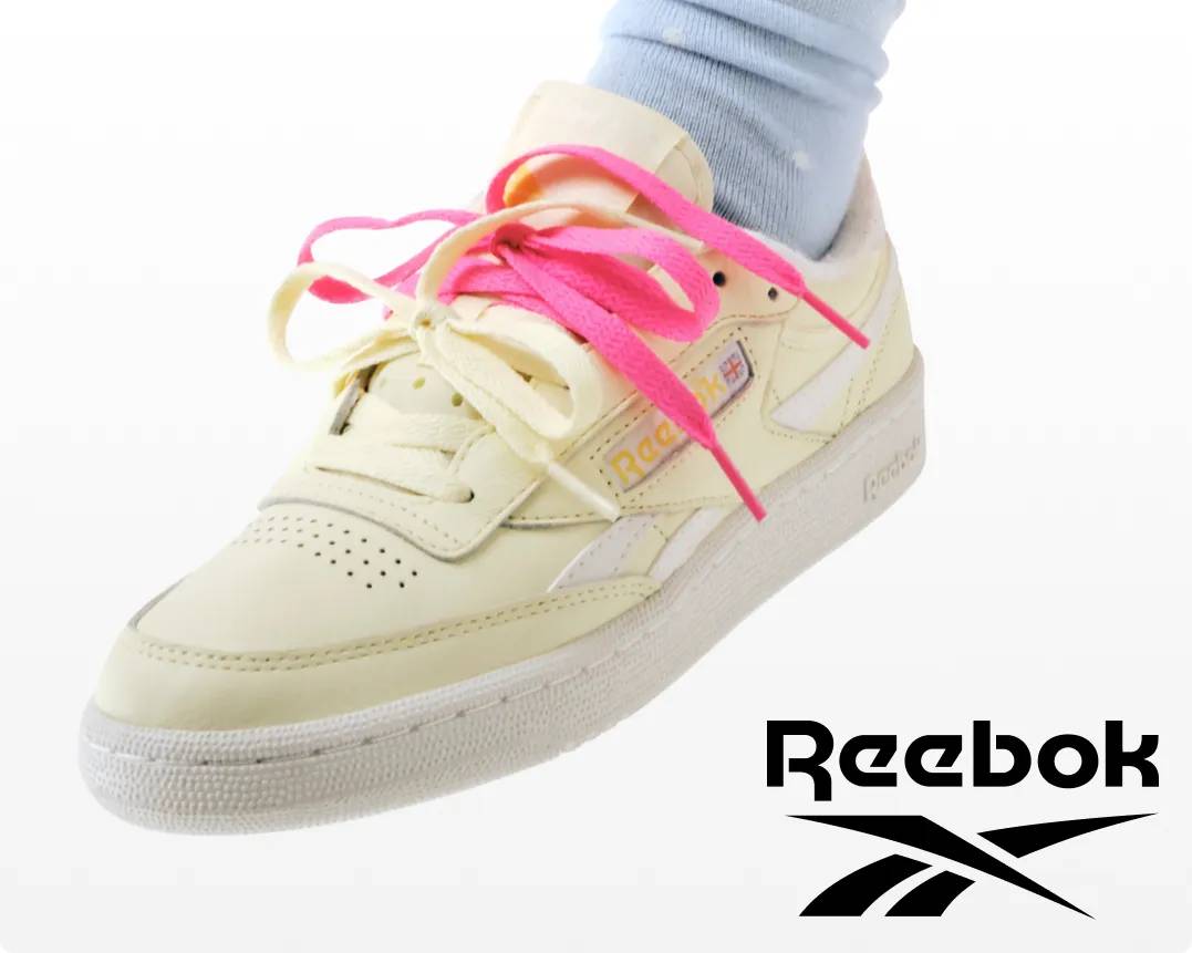 Featuring a white pair of Reebok sneakers with pink shoe laces.