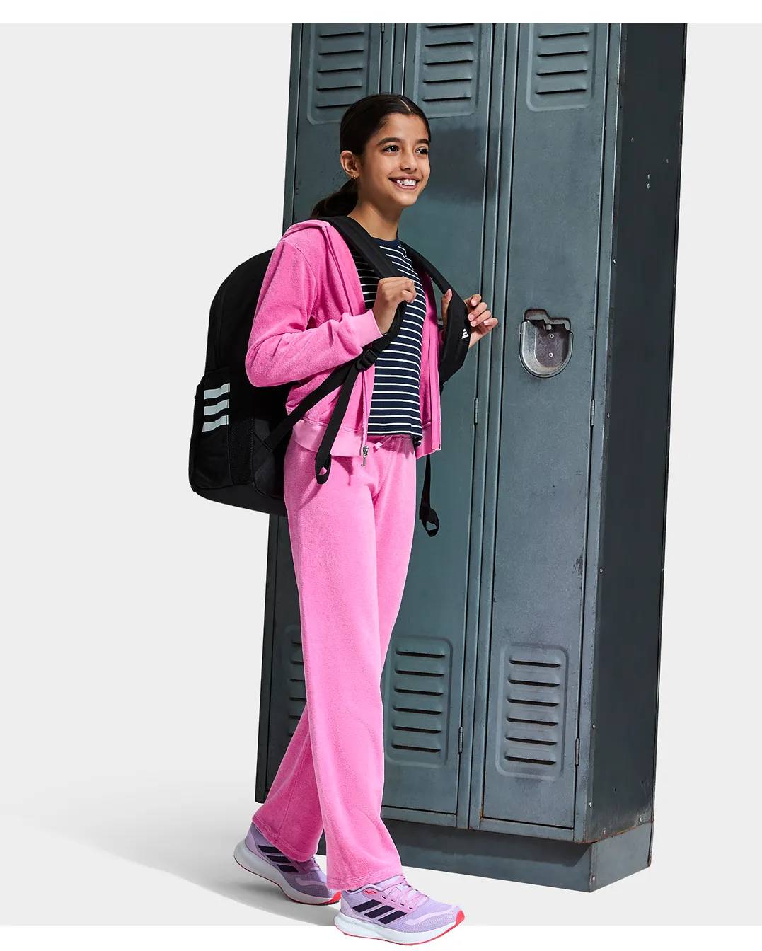 Girl wearing purple adidas sneakers next to school lockers