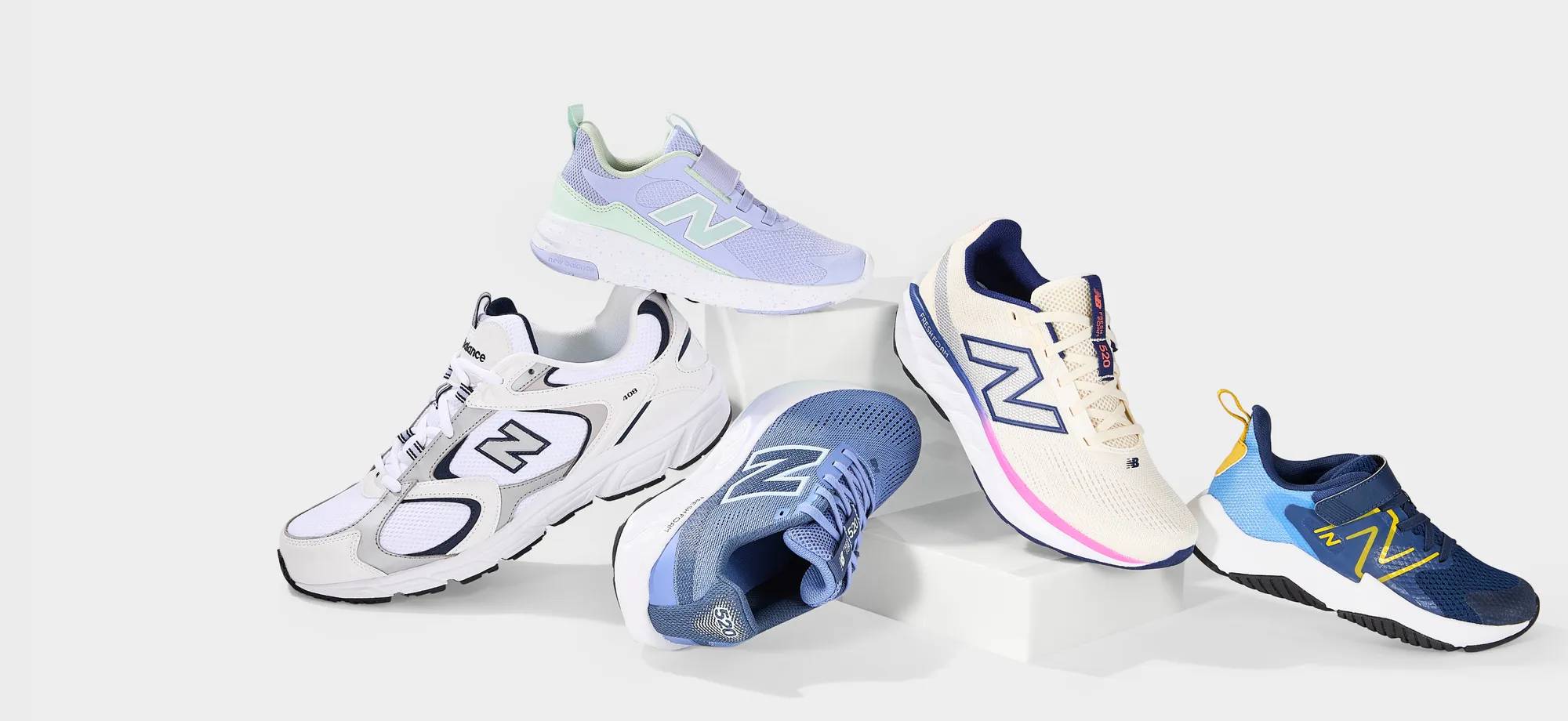 5 different coloured New Balance sneakers stacked on top of each other