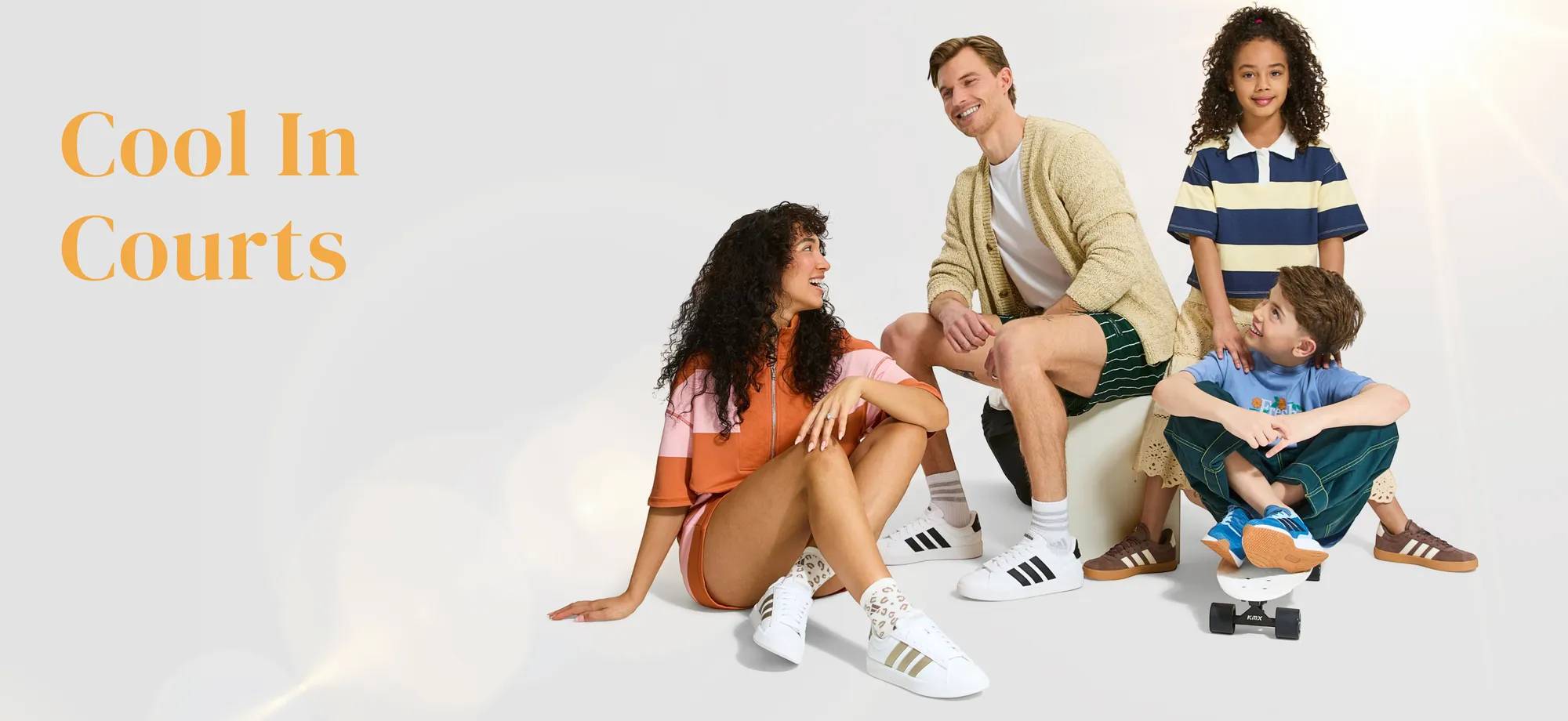 Family of 4 sitting down wearing adidas court sneakers