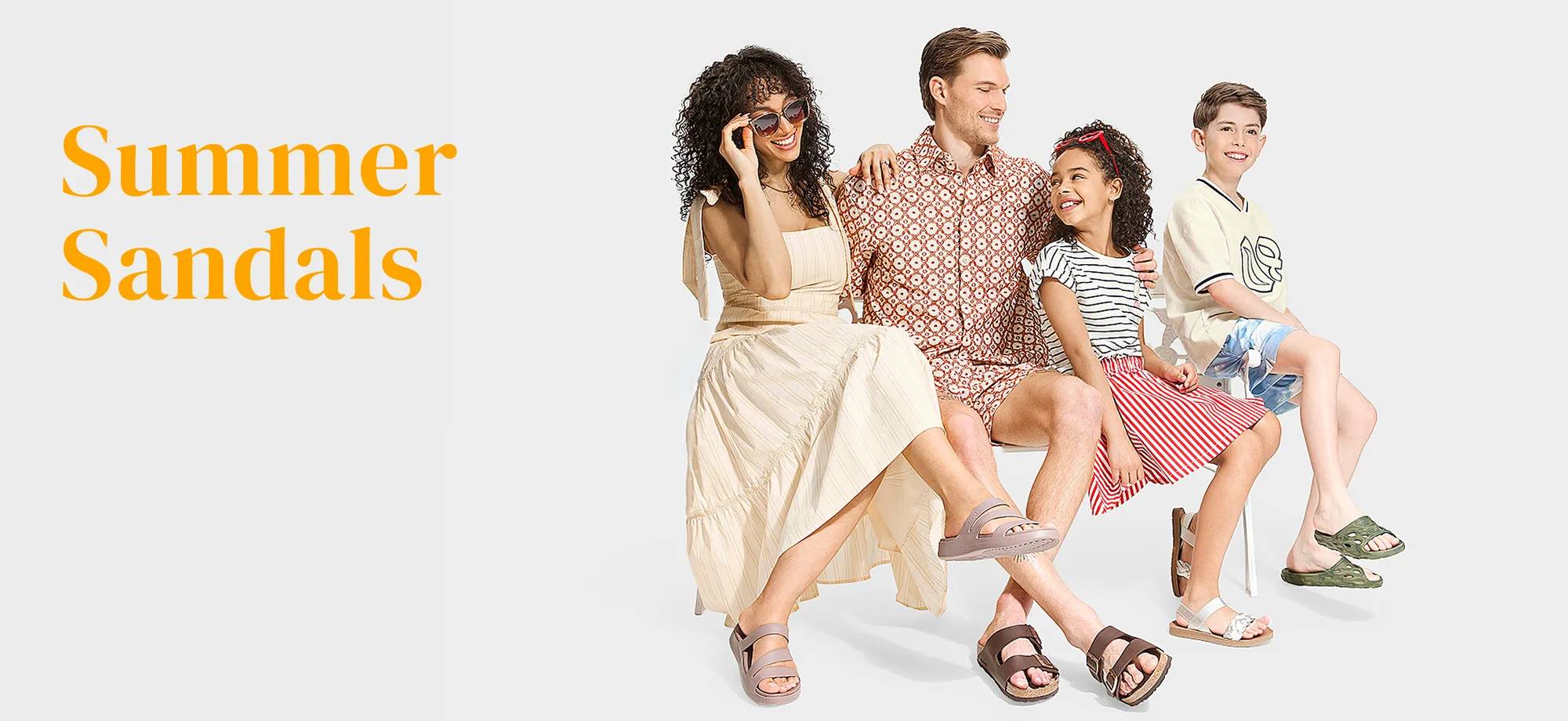 A family of 4 dressed in summer clothing and sandals