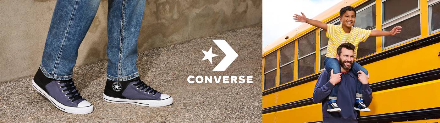 Boy on father's shoulders wearing Converse sneakers with a school bus in the background