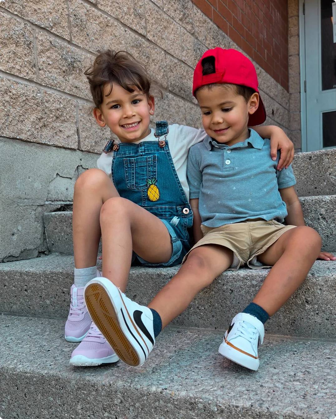 Two siblings sitting on steps