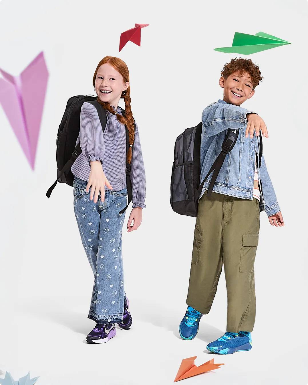 Girl and boy throwing paper airplanes