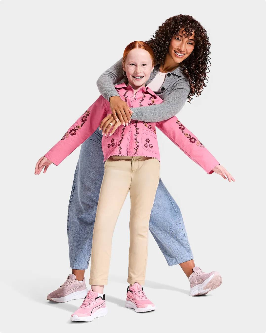 A girl wearing pink sneakers and woman behind her wearing pink sneakers