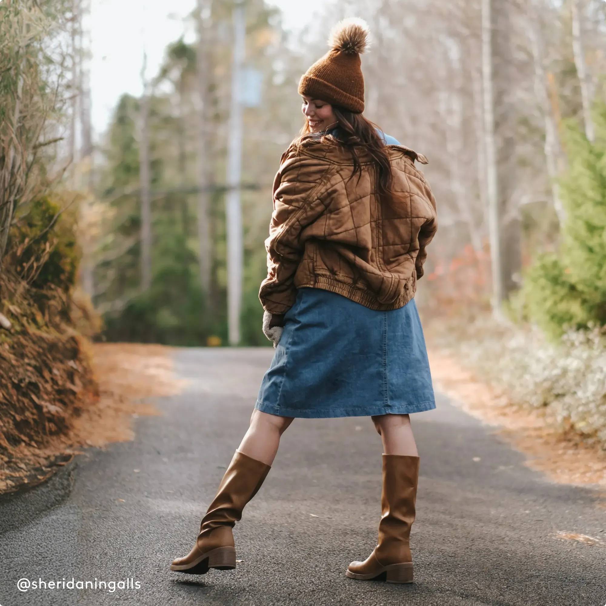 Woman with brown knee high boots standing on a path