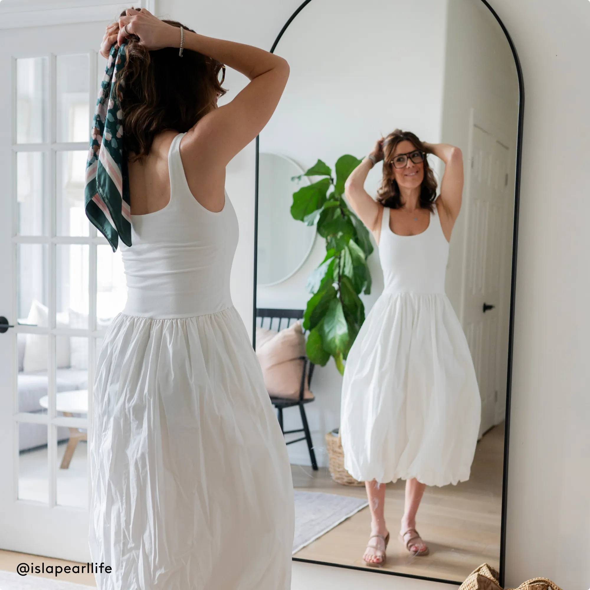 Woman wearing jelly sandals looking at herself in the mirror