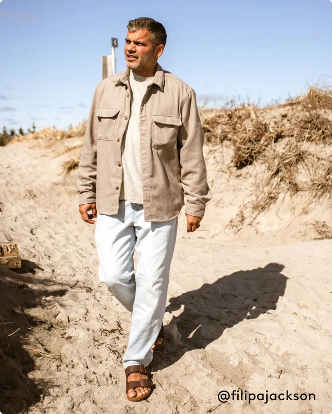 Man walking in sand with brown Birkenstock sandals