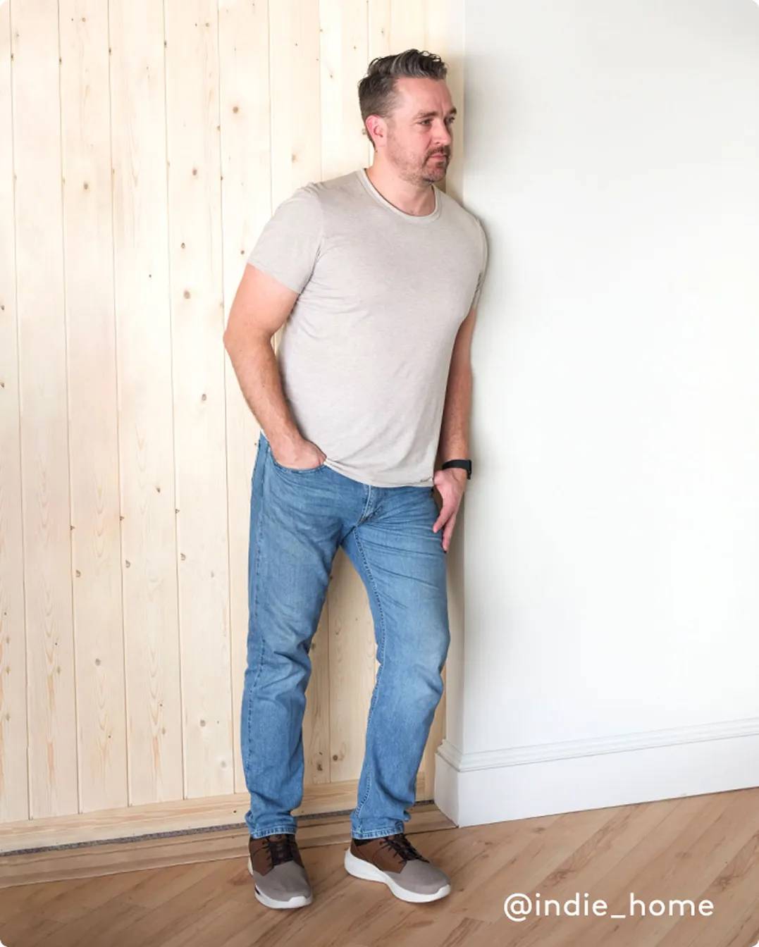 Man leaning against the wall while wearing grey and brown casual shoes