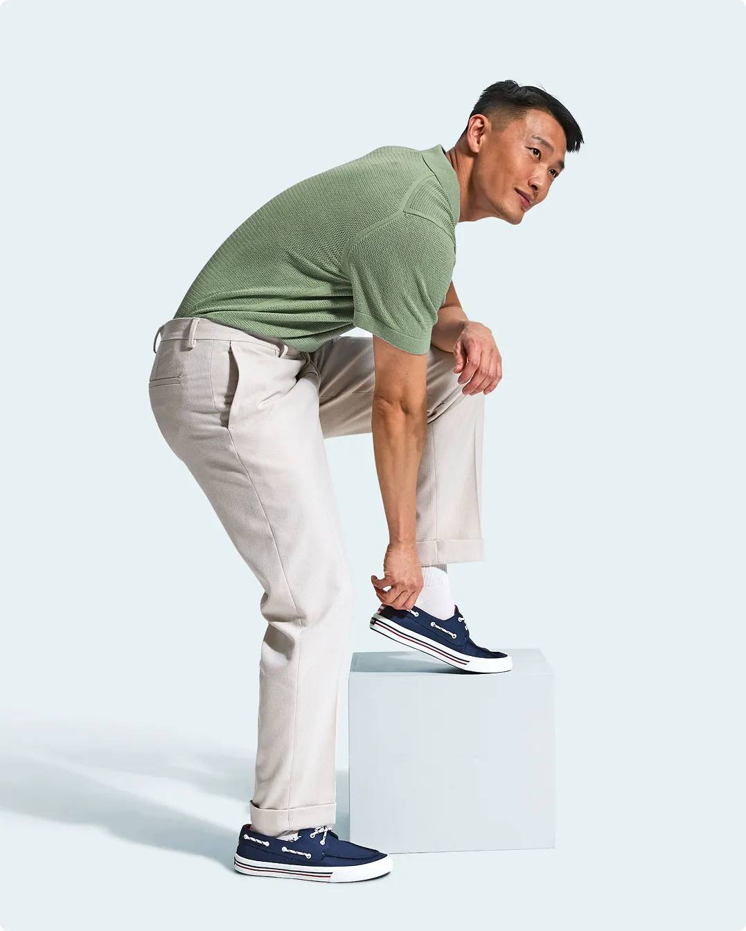 Man putting on blue boat shoes