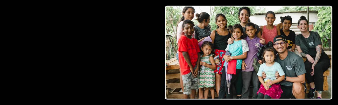 Group photo of The Shoe Co. employees with kids from a South American country